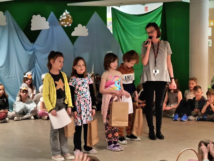 Czwórka dzieci odbierających nagrody na scenie.