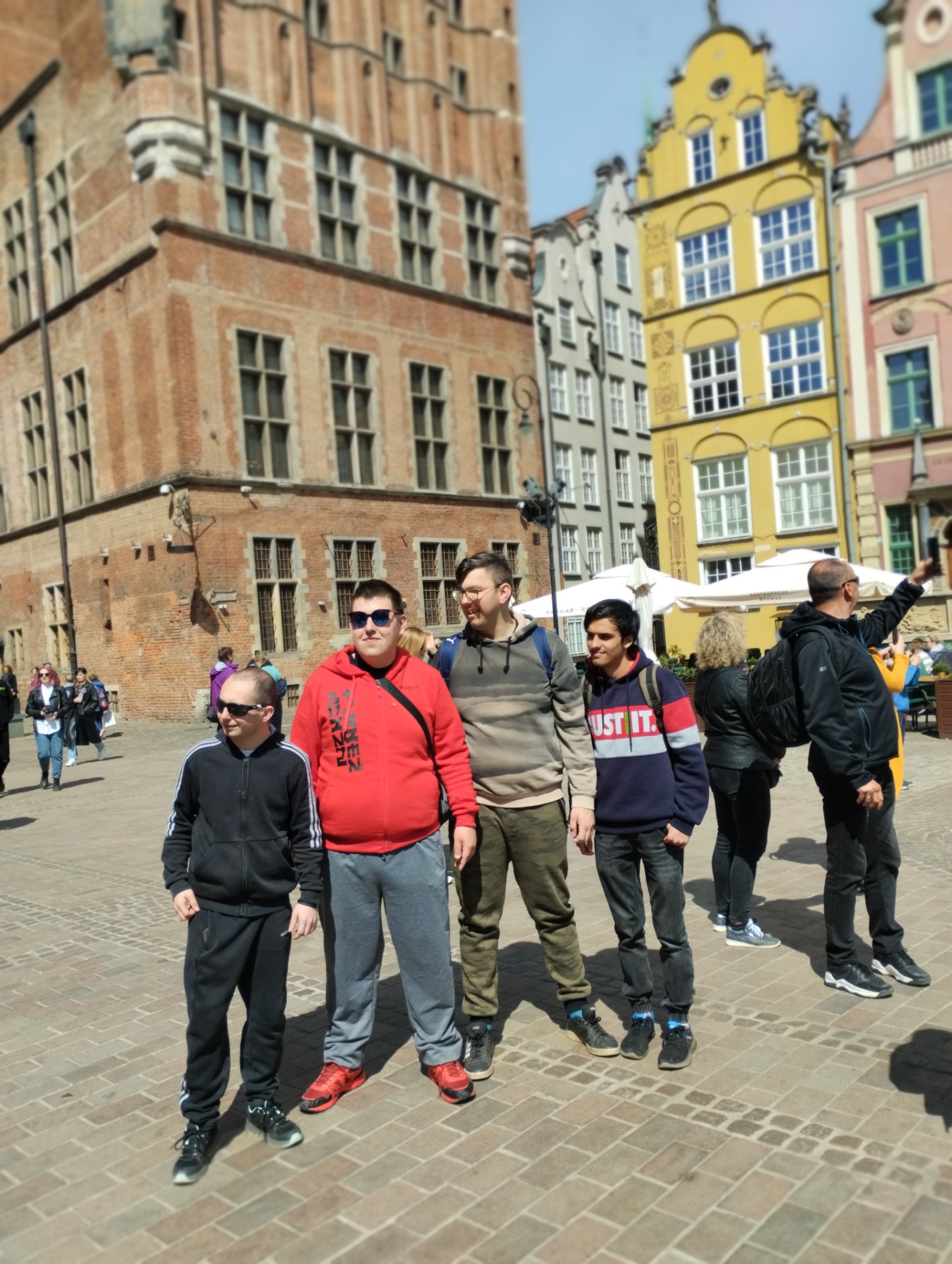 Uczniowie spacerujący ulicą Długą w Gdańsku, w tle gdańskie kamienice mieszczańskie.
