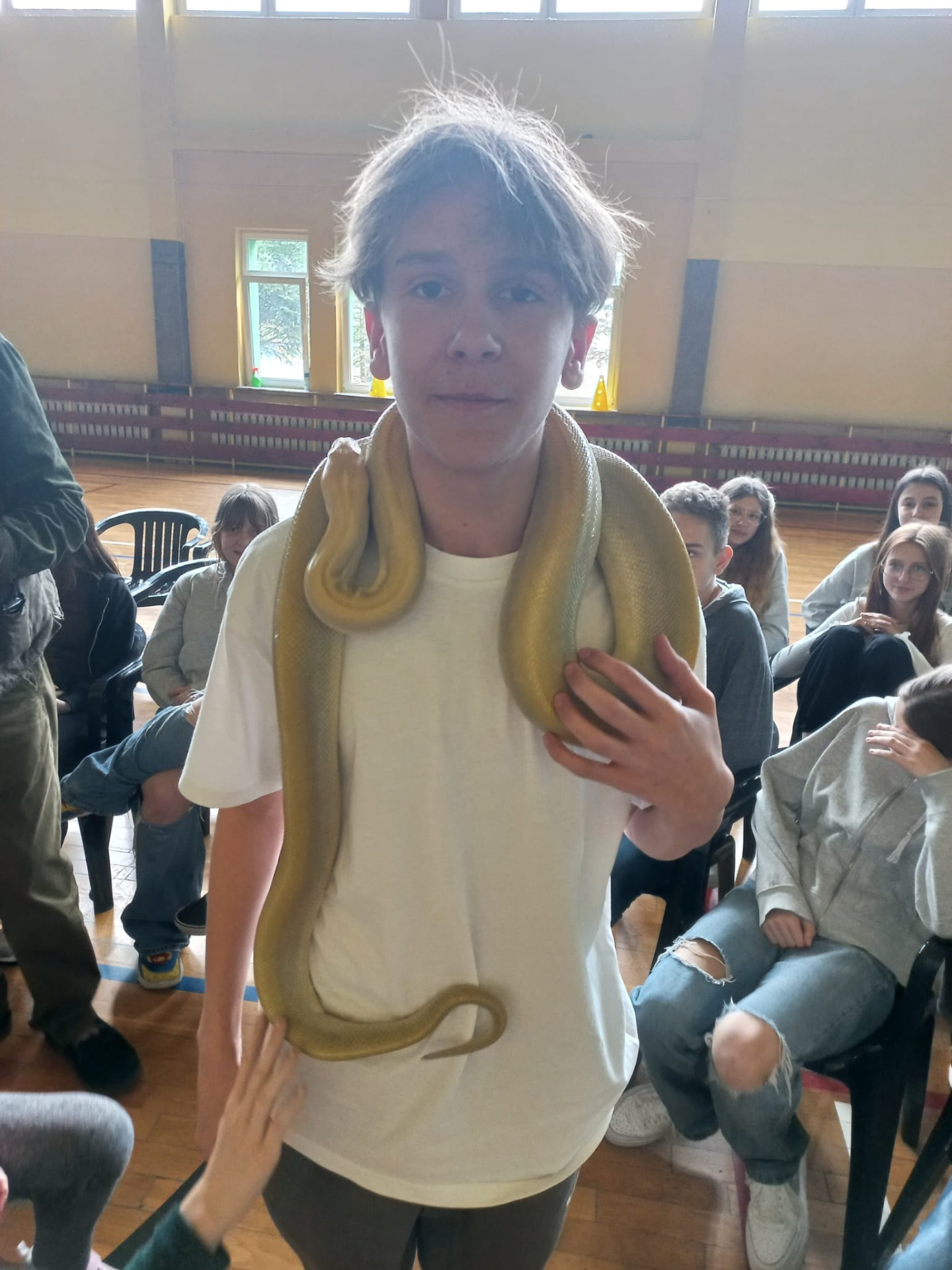 Uczeń trzyma na szyi węża pytona.