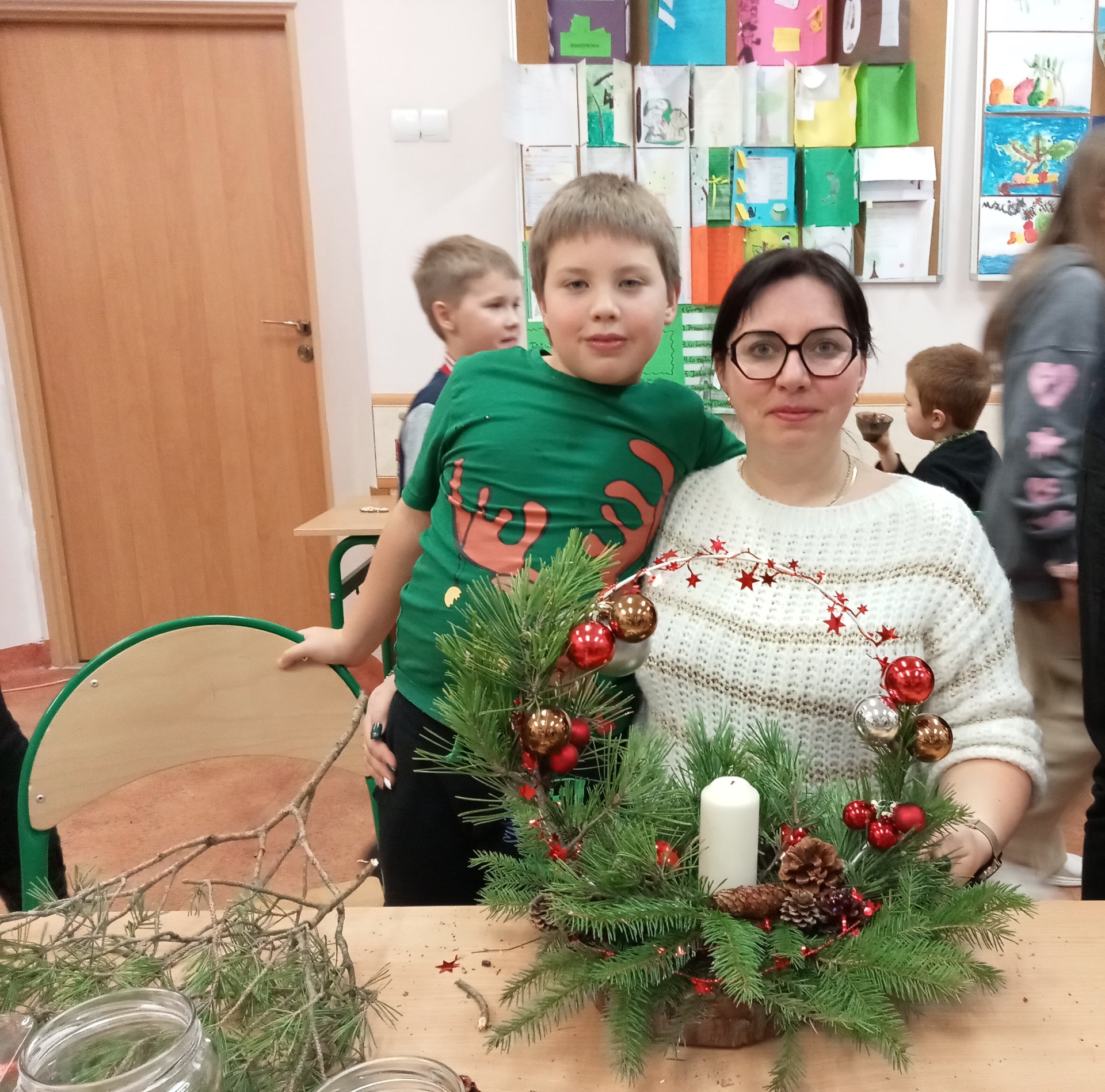 Uczniowie i rodzice podczas wykonywania bożonarodzeniowych stroików i ozdób