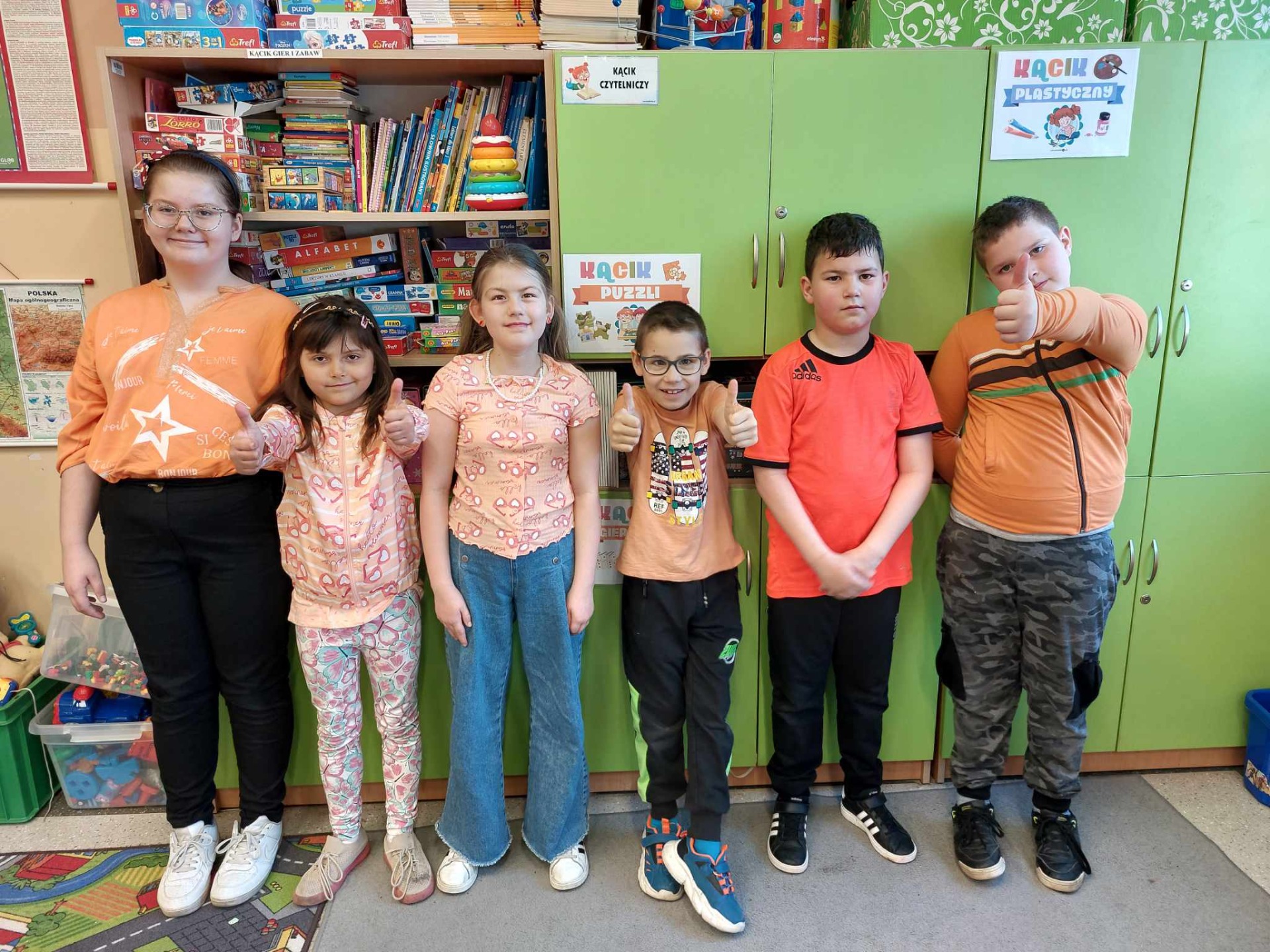 grupa młodszych dzieci z klasy 1-2 w pomarańczowych strojach