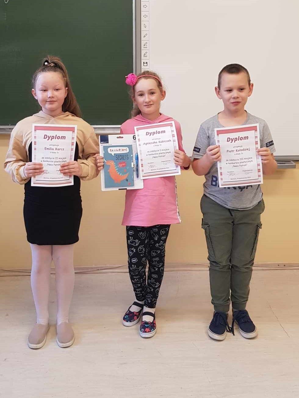 Trójka uczniów z nagrodami konkursowymi