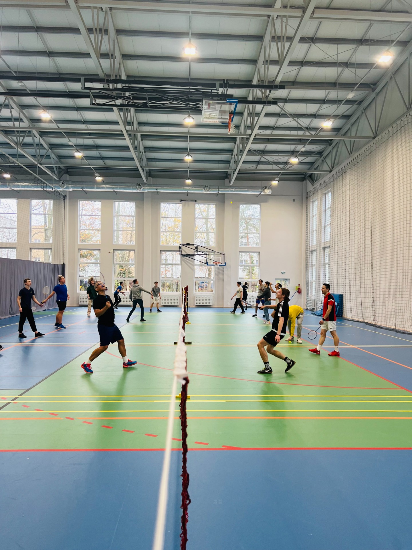 Uczniowie w trakcie gry w badmintona na sali gimnastycznej. Zdjęcie grupowe. 