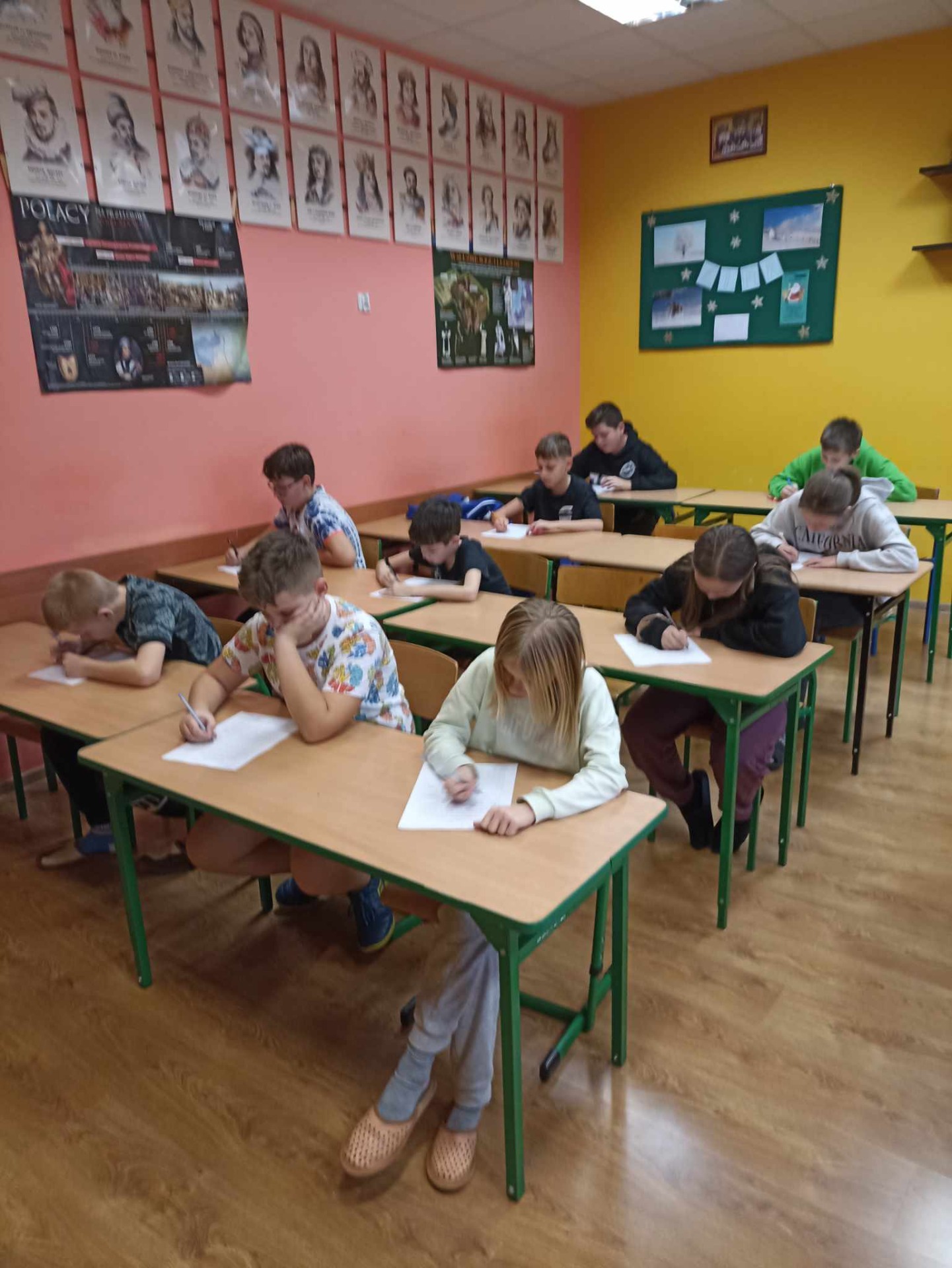 Uczniowie piszą dyktando w klasie 