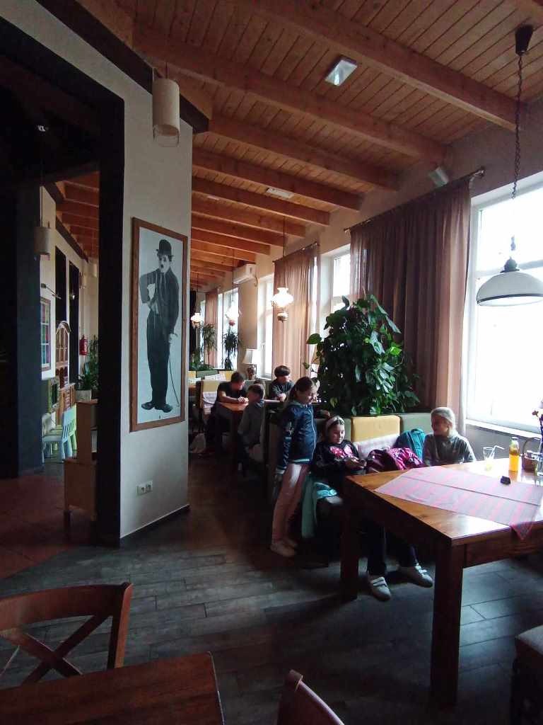 Uczestnicy wycieczki siedzą przy stolikach w restauracji.