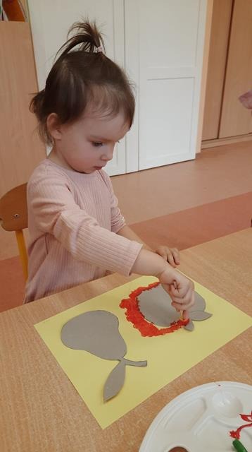 dziecko maluje jabłko