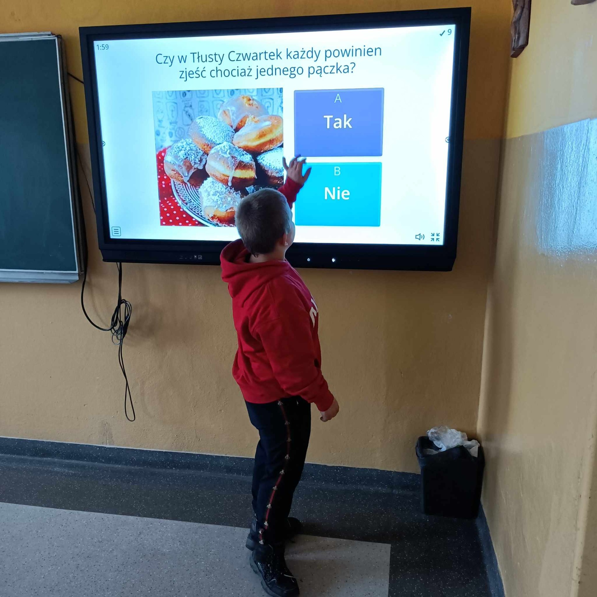 Uczeń korzysta z tablicy interaktywnej grające w grę dotyczącą pączków