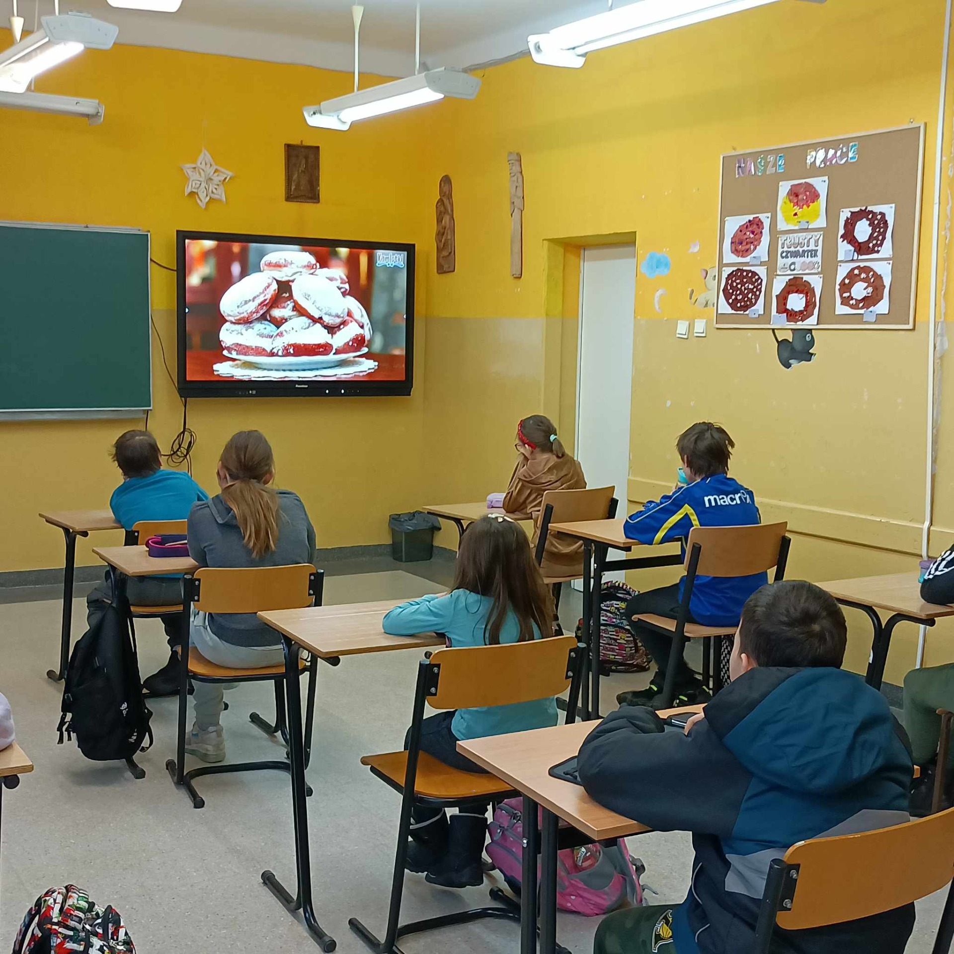 Uczniowie oglądają film edukacyjny dotyczący historii tłustego czwartku