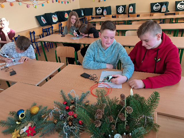 Dwójka uczniów pracuje długopisami 3D nad ozdobą bożonarodzeniową.