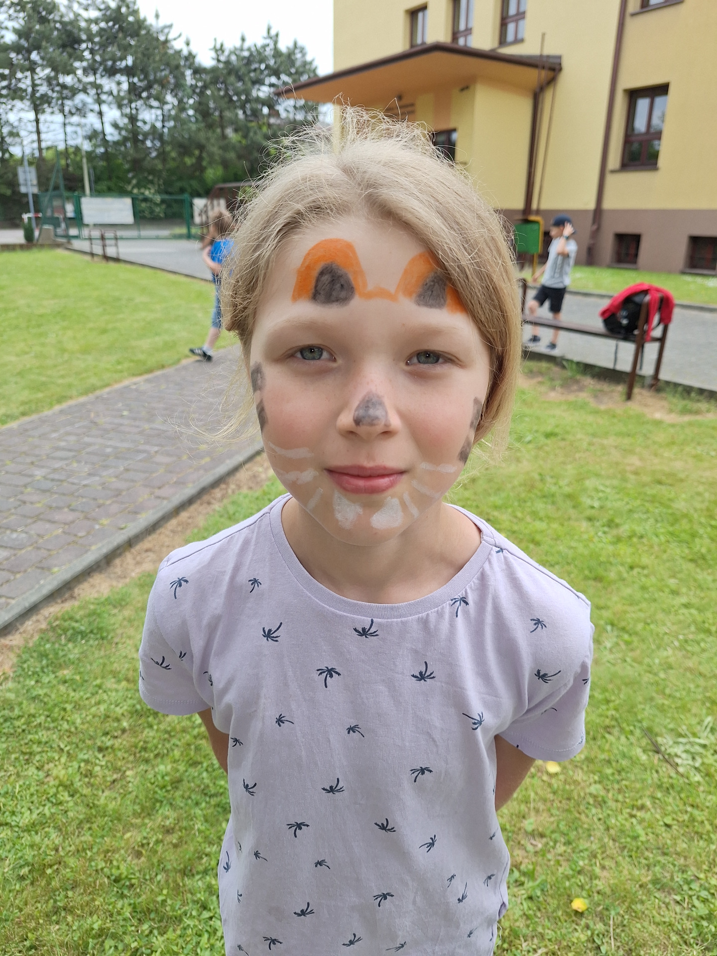 Dziecko z namalowanym na twarzy tygryskiem