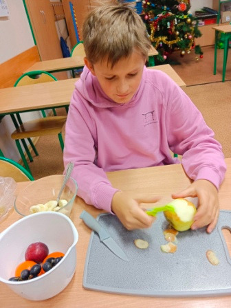 Uczeń przygotowujący sałatkę owocową