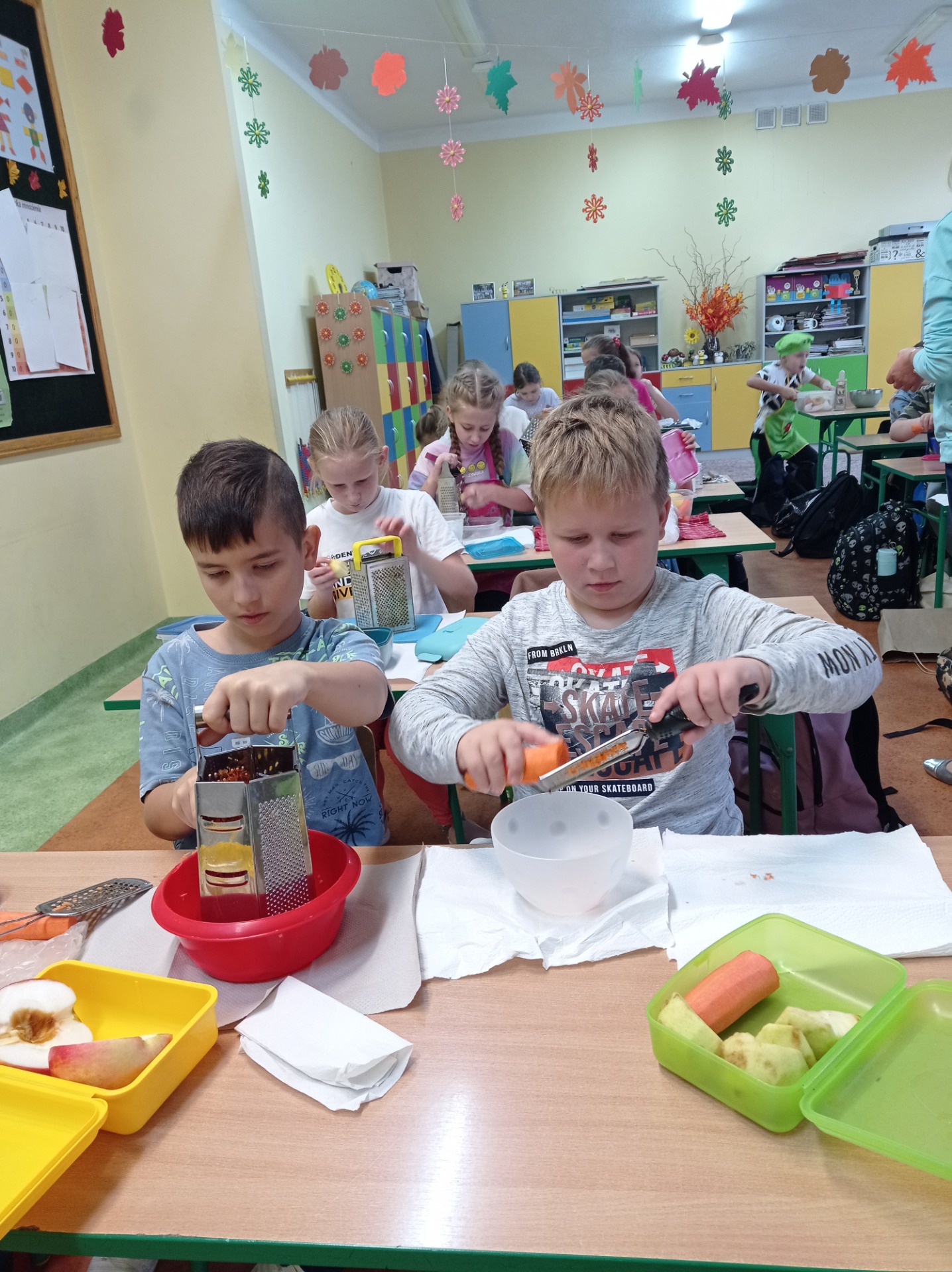 Uczniowie w skupieniu robią surówkę z marchewki i jabłka.